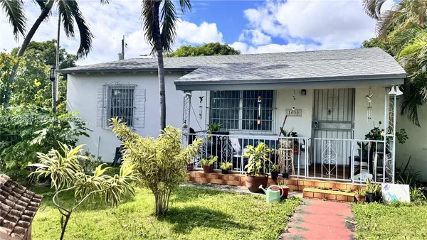 front view of house with a yard and potted plants
