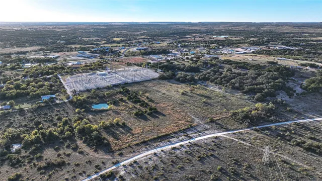 an aerial view of house with yard and mountain view in back