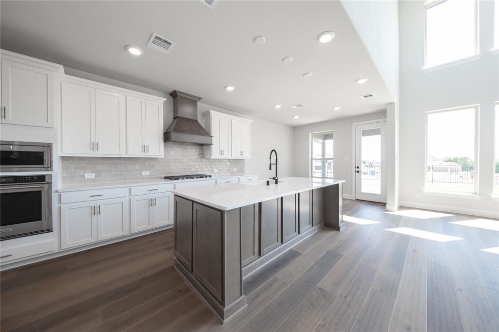 3307 Guardian Angel Court Heath, TX 75126 - Photo 4 of 40 a kitchen with white cabinets and white appliances