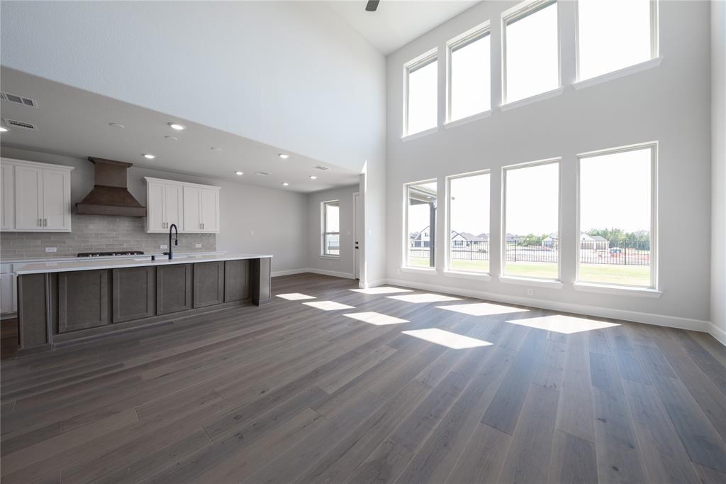 3307 Guardian Angel Court Heath, TX 75126 - Photo 9 of 40 a view of an empty room with wooden floor and a kitchen