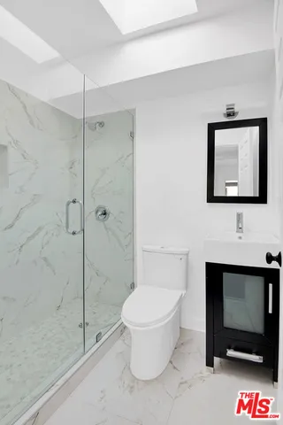 a bathroom with a toilet a sink and shower