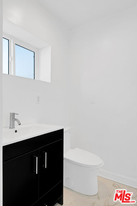 1610 South Beverly Glen Boulevard, Unit 6 Los Angeles, CA 90024 - Photo 13 of 16 a bathroom with a sink a toilet and a mirror