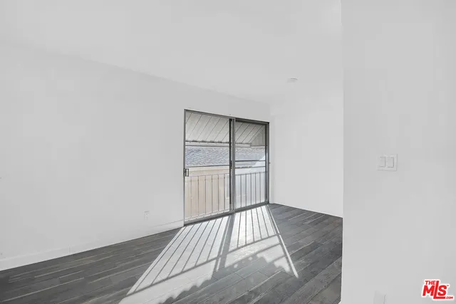 a view of a room with wooden floor and white walls