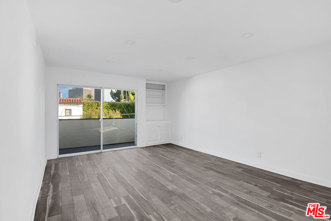 1610 South Beverly Glen Boulevard, Unit 6 Los Angeles, CA 90024 - Photo 7 of 16 an empty room with wooden floor and windows