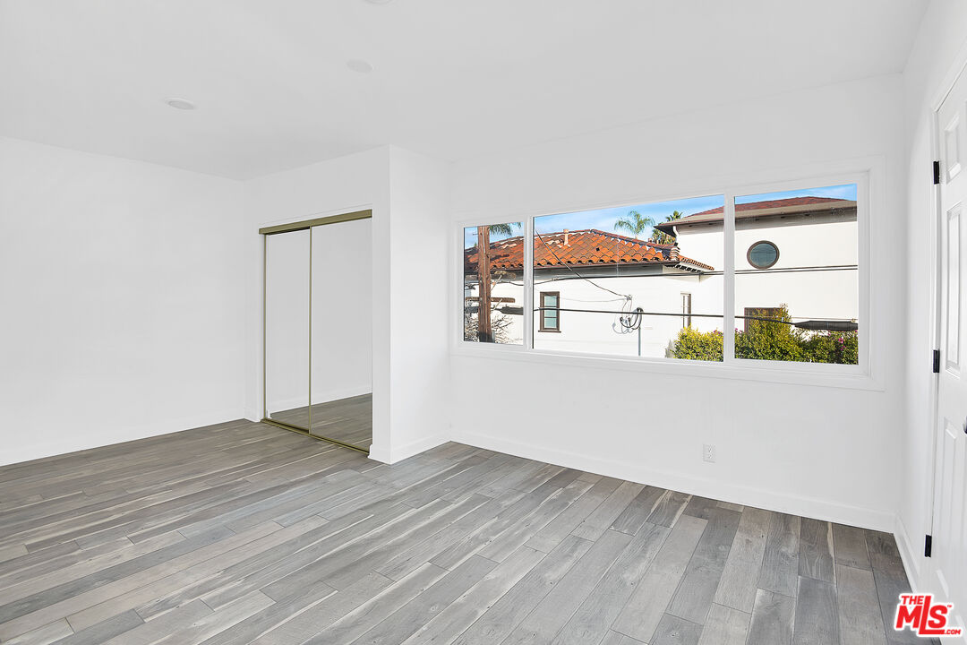 1610 South Beverly Glen Boulevard, Unit 6 Los Angeles, CA 90024 - Photo 9 of 16 an empty room with wooden floor and windows