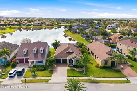 an aerial view of residential houses with outdoor space and ocean view