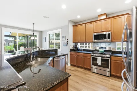 a kitchen with stainless steel appliances granite countertop a stove a sink and a microwave