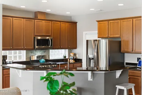 a kitchen with stainless steel appliances granite countertop a refrigerator a stove top oven a sink and dishwasher