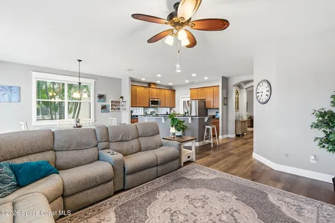 a living room with furniture kitchen view and a large window