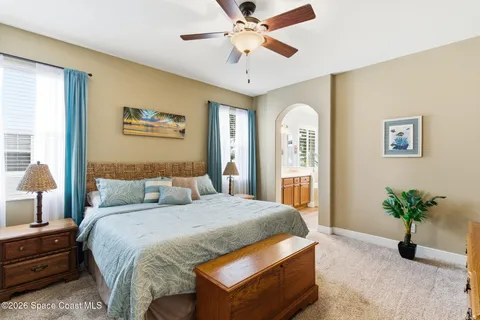 a bedroom with a large bed and a chandelier