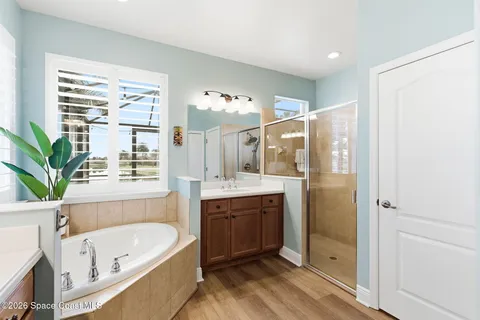a bathroom with a tub a sink and a large mirror