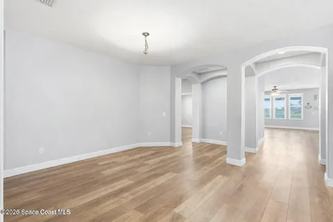 a view of an empty room with wooden floor