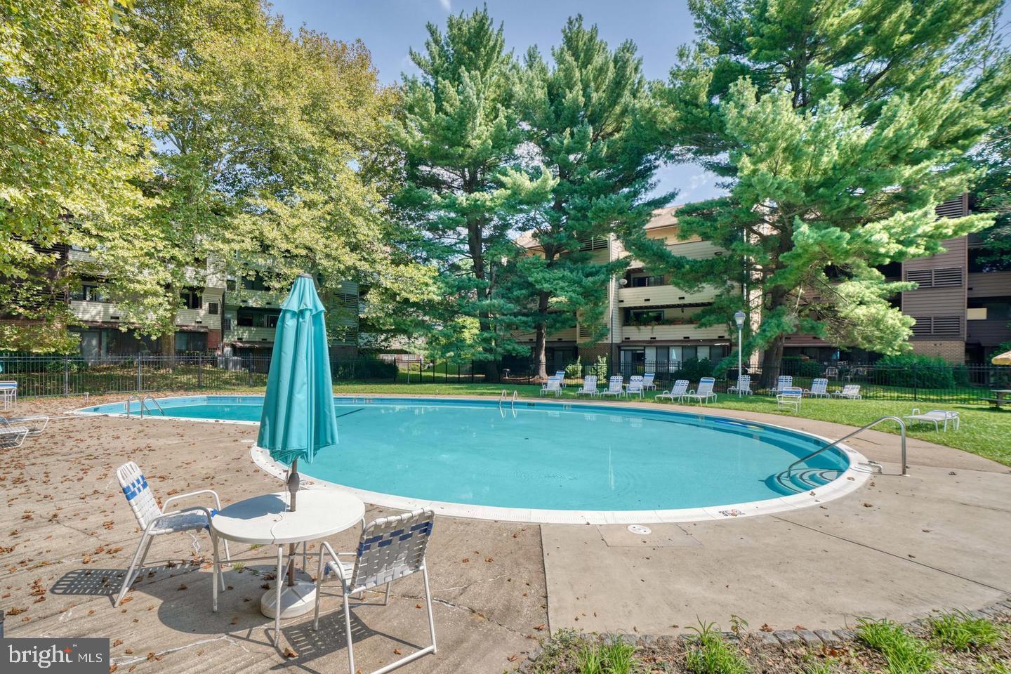 6 Longstream Court, Unit T1 Baltimore, MD 21209 - Photo 25 of 25 a view of pool with table and chairs and plants