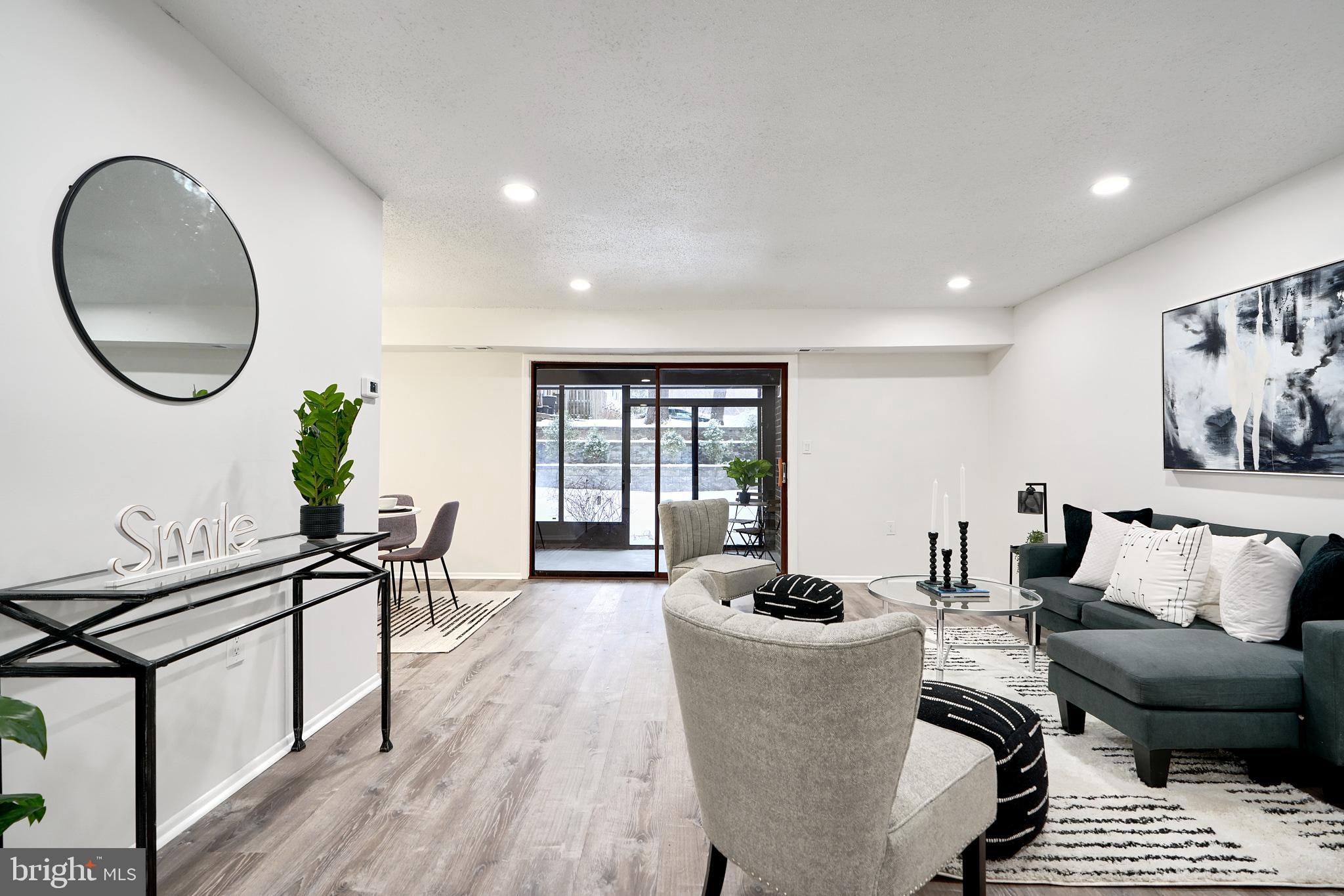 6 Longstream Court, Unit T1 Baltimore, MD 21209 - Photo 3 of 25 a living room with furniture a wooden floor and a large window