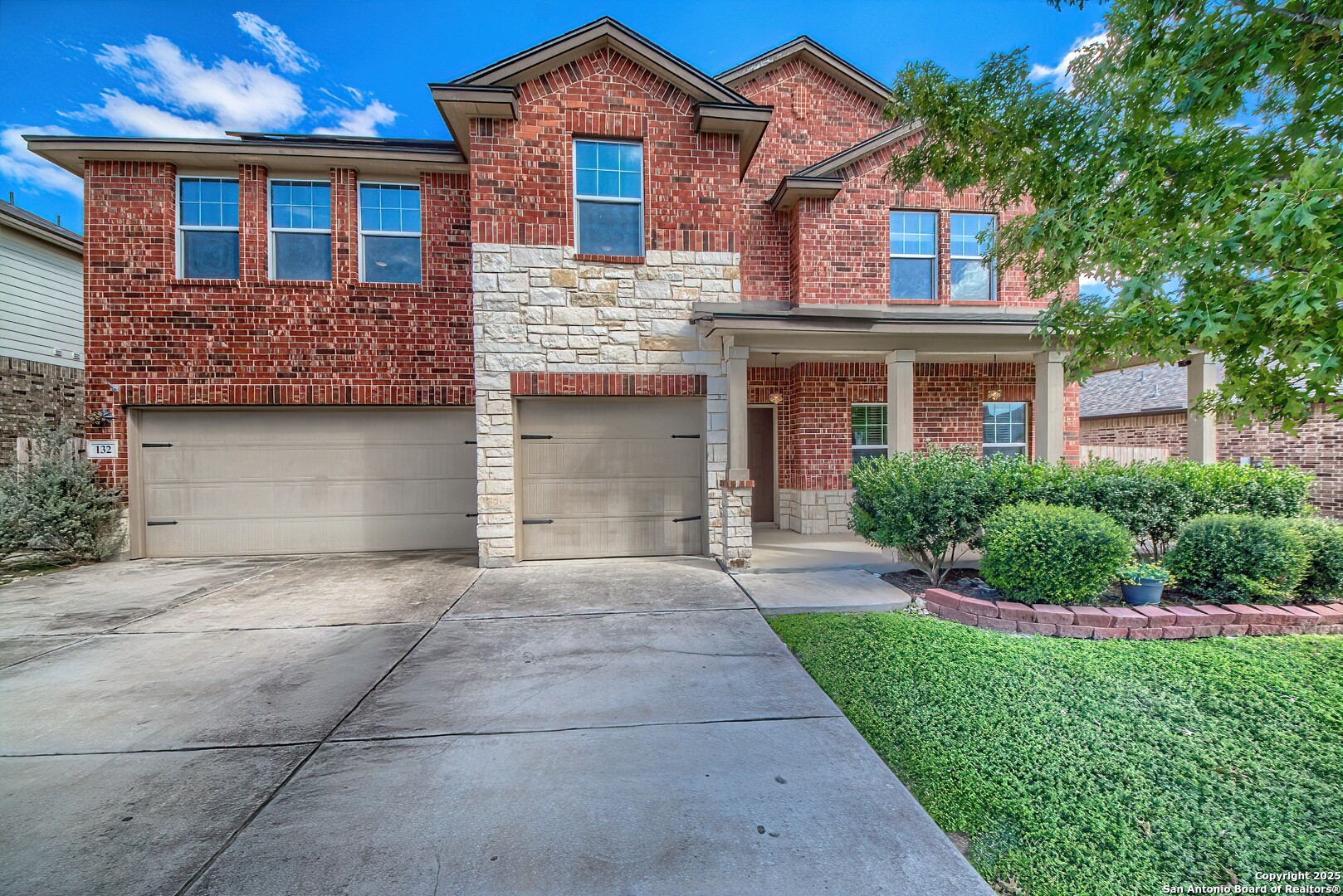 a front view of a house with a garden and garage