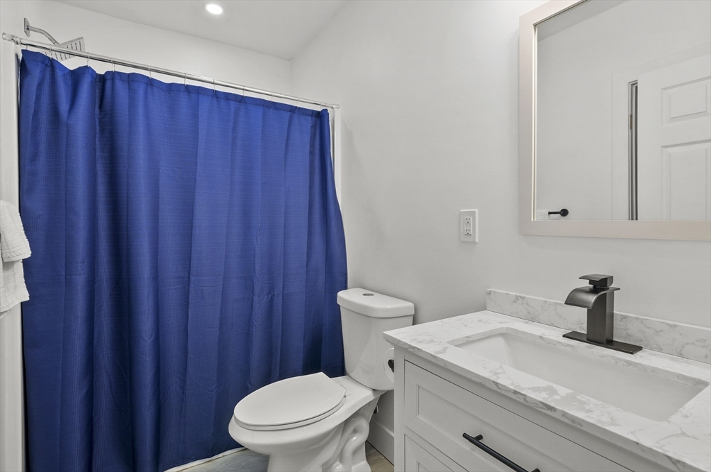 607 Cambridge Street, Unit 4 Worcester, MA 01610 - Photo 15 of 29 a bathroom with a sink a toilet and shower curtain