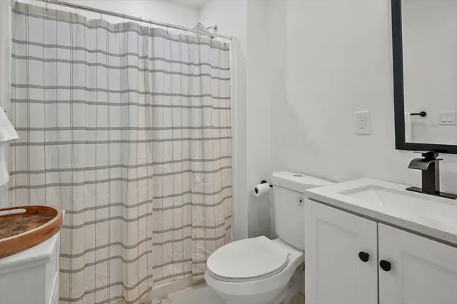 a bathroom with a granite countertop toilet and a sink