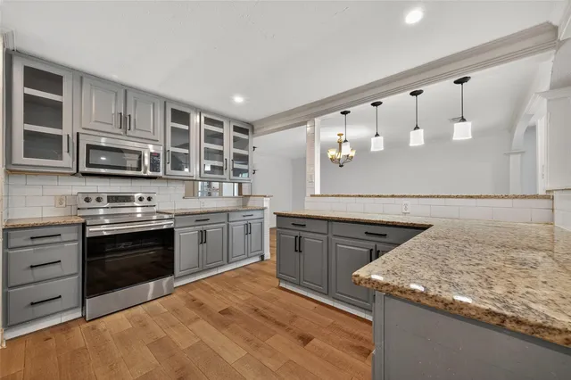 a kitchen with stainless steel appliances granite countertop a stove and cabinets