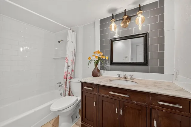 a bathroom with a granite countertop sink a toilet and shower