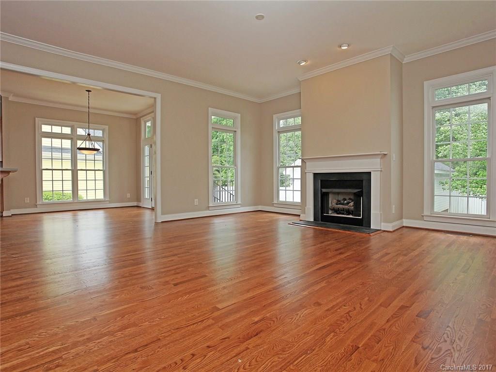 2416 Commons Court Fort Mill, SC 29708 - Photo 11 of 24 an empty room with wooden floor fireplace and windows