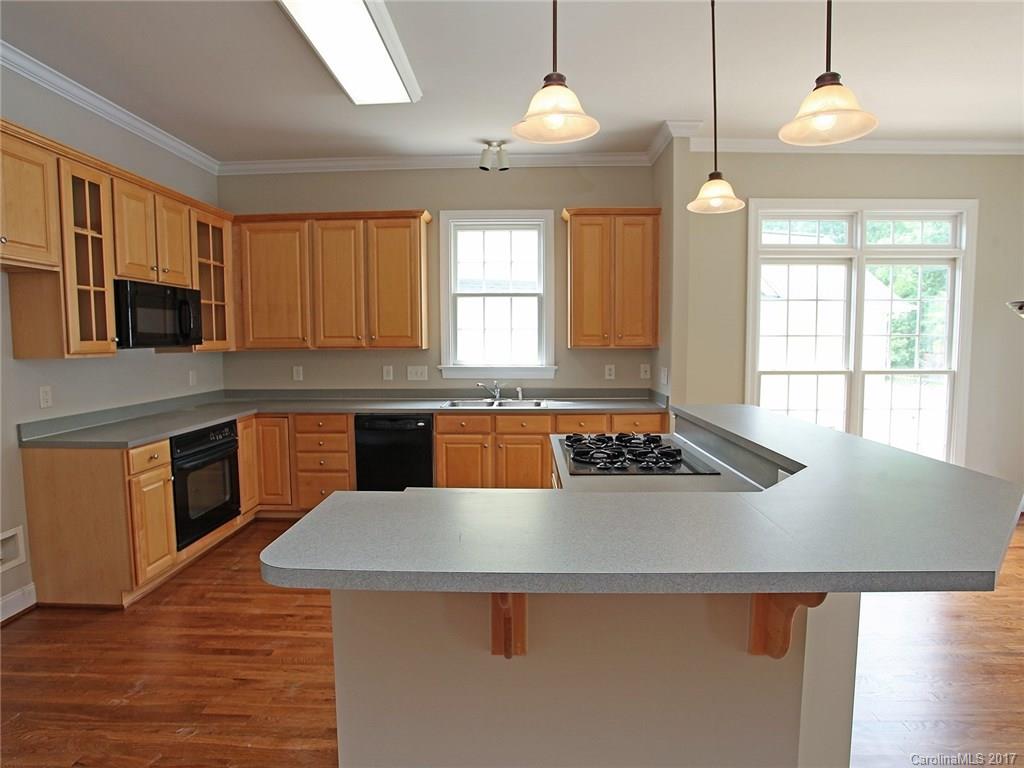 2416 Commons Court Fort Mill, SC 29708 - Photo 14 of 24 a kitchen with a stove a sink a counter space and a window