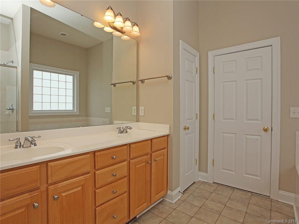 2416 Commons Court Fort Mill, SC 29708 - Photo 18 of 24 a bathroom with a double vanity sink a mirror and a bathtub