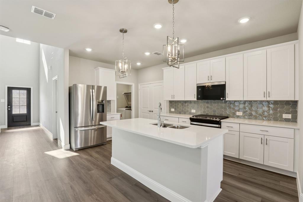 a kitchen with stainless steel appliances a stove refrigerator sink and microwave