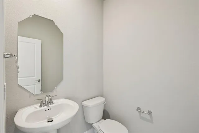 a bathroom with a toilet a sink and mirror