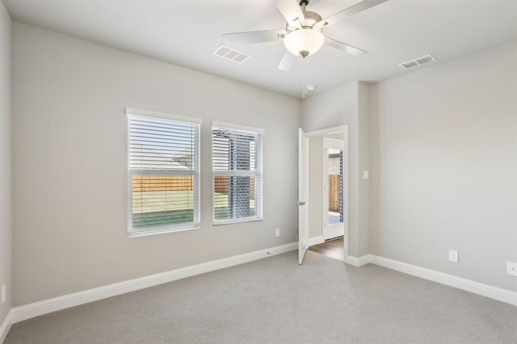 1729 Arches Road Anna, TX 75409 - Photo 13 of 27 an empty room with chandelier fan and windows