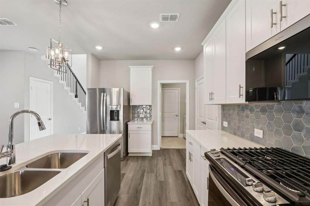 1729 Arches Road Anna, TX 75409 - Photo 6 of 27 a kitchen with refrigerator a sink and a stove