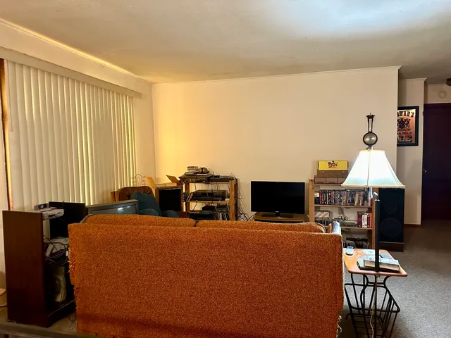 a living room with furniture a flat screen tv and a window