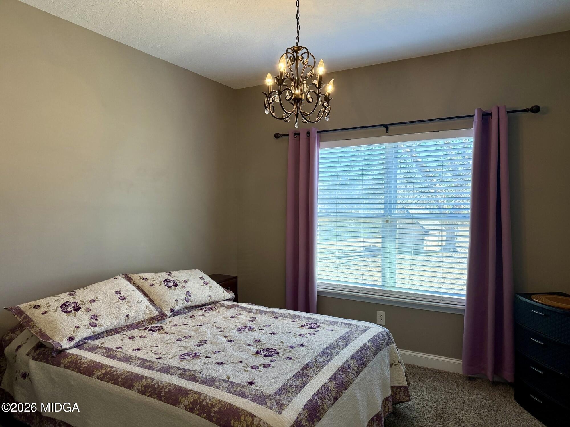 159 Jockey Lane Cochran, GA 31014 - Photo 21 of 39 a bedroom with a bed and a chandelier