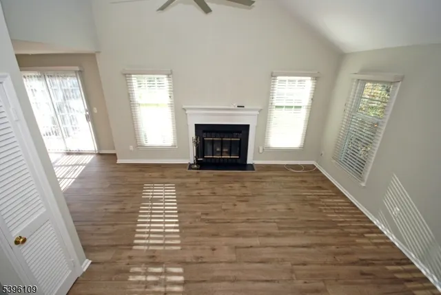 a view of a livingroom with wooden floor and a fireplace