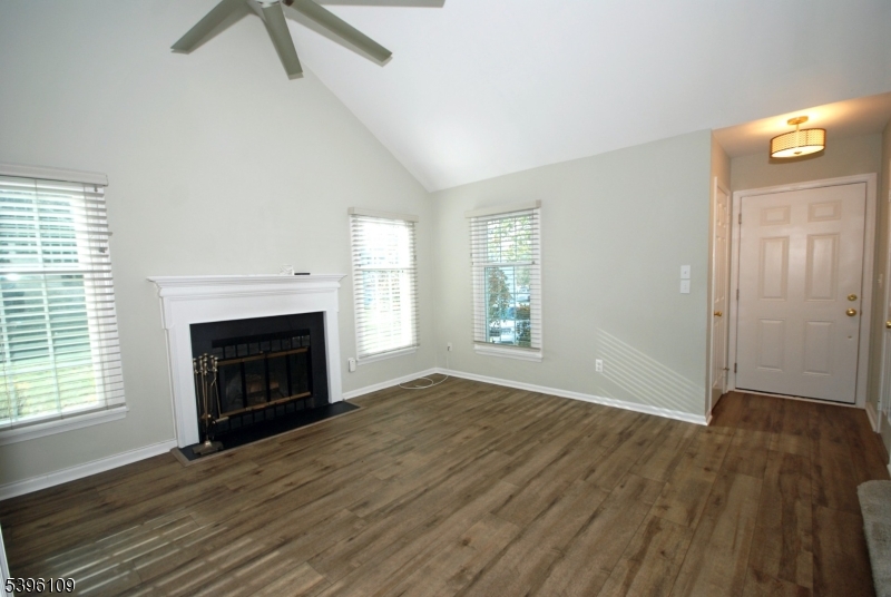 374 Burdock Court Three Bridges, NJ 08887 - Photo 6 of 16 an empty room with windows a fireplace and wooden floor