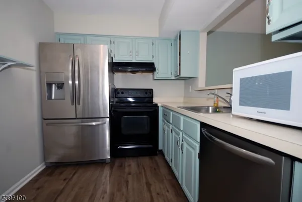 a kitchen with a refrigerator and a stove top oven
