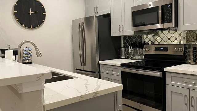 a kitchen with stainless steel appliances a stove microwave and refrigerator