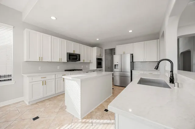 a kitchen with stainless steel appliances granite countertop white cabinets and a stove