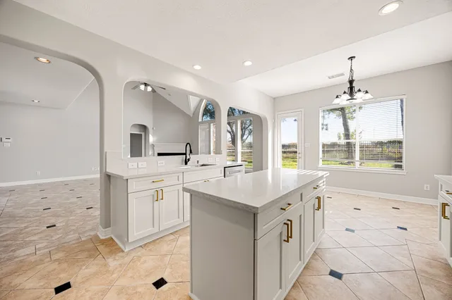 a kitchen with kitchen island a sink appliances and cabinets