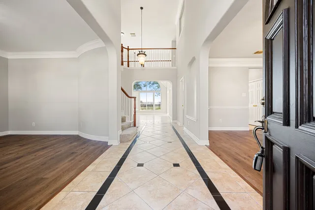 a view of a hallway with wooden floor and staircase