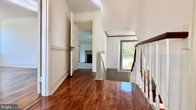 a view of a living room with wooden floor and a fireplace