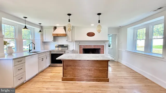 a kitchen with stainless steel appliances granite countertop a stove and a wooden floors
