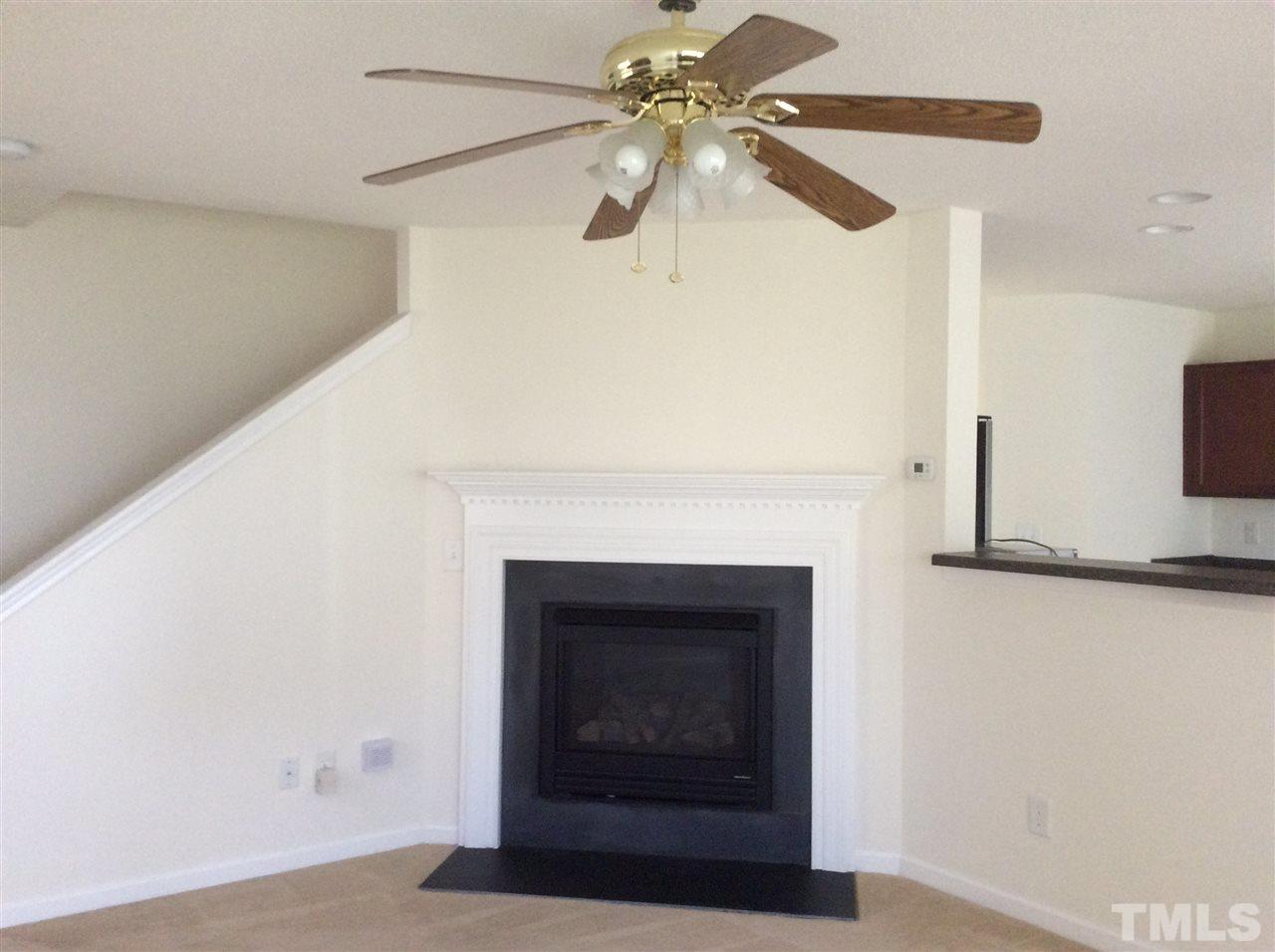 3729 Marshlane Way Raleigh, NC 27610 - Photo 4 of 16 a living room with a fireplace and a ceiling fan