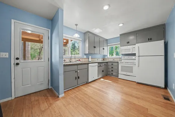 an empty room with windows and cabinet