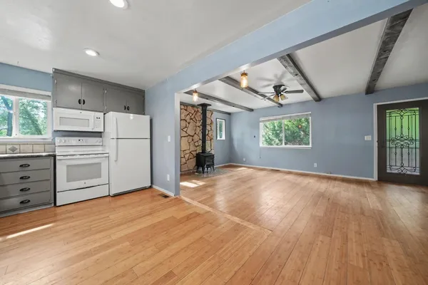 a kitchen with stainless steel appliances and wooden floor