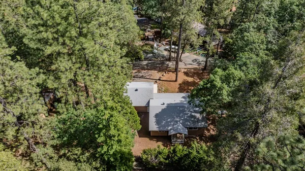 a aerial view of a house with a yard and large trees