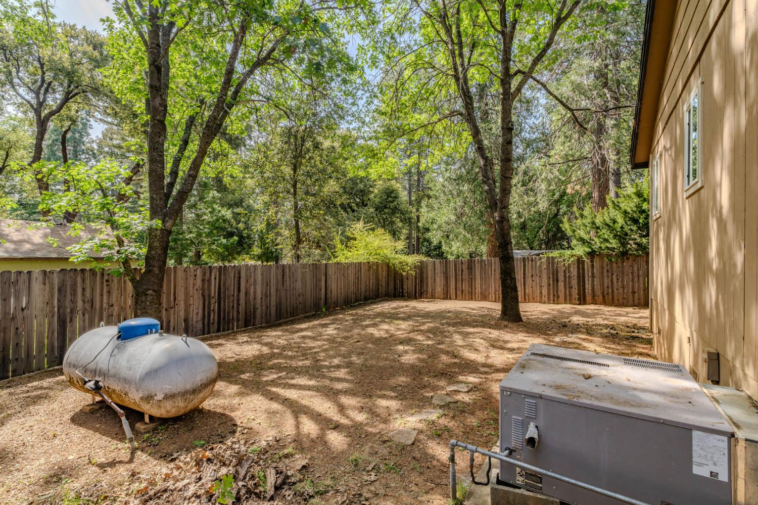 19479 Murphy Road Pine Grove, CA 95665 - Photo 33 of 43 a backyard of a house with table and chairs a barbeque with wooden fence and floor