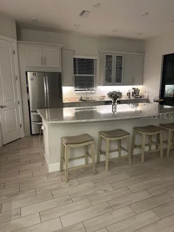 a kitchen with stainless steel appliances granite countertop a sink and a refrigerator
