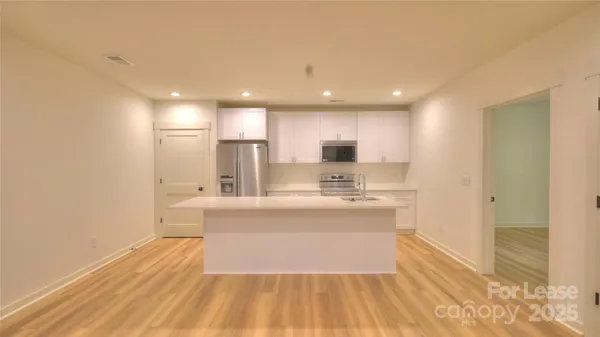 a view of kitchen with wooden floor and electronic appliances