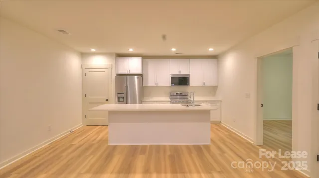 a view of kitchen with wooden floor and electronic appliances