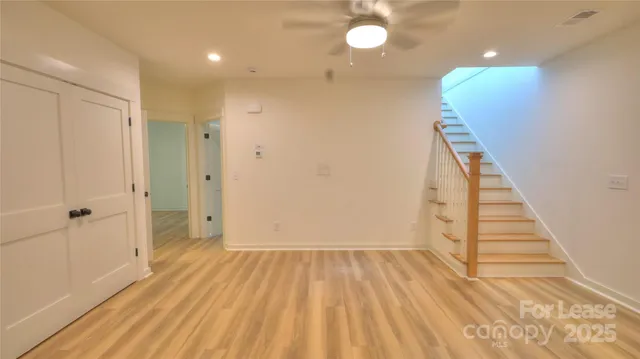 a view of a hallway with wooden floor and staircase